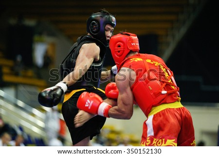 JAKARTA, INDONESIA - NOVEMBER 16, 2015: Mohsen Mohammadseifi of Iran (red) fights Van Tai Nguyen of Vietnam (black) in the men's 70kg Sanda event at the 13th World Wushu Championship 2015.