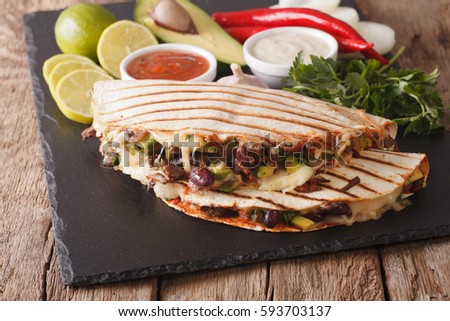 quesadilla with minced beef, beans, avocado and cheese close-up on the table. horizontal