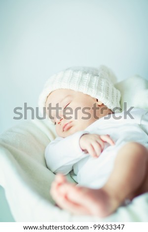 picture of a newborn baby curled up sleeping on a blanket