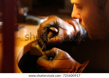 Jeweler engraving the ring with sharp awl