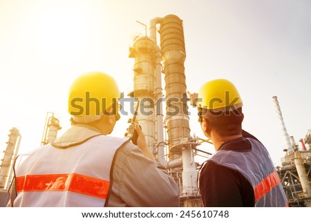 refinery workers discussion and pointing for inspection