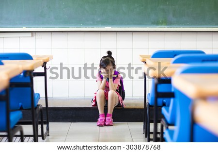 stress girl sitting and thinking on the classroom floor