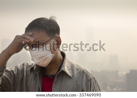 Asian man wearing mouth mask against air pollution
