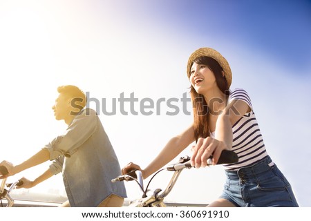 Happy young couple going for bicycle ride on a sunny day