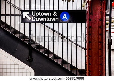 New York City Subway inside and underground with steps and directional sign for Uptown Downtown A train.