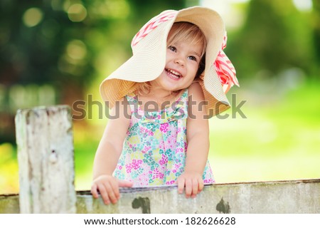 Portrait of a happy little girl in countryside at green background
