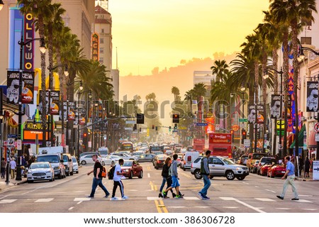 LOS ANGELES, CALIFORNIA - MARCH 1, 2016: Traffic and pedestrians on Hollywood Boulevard at dusk. The theater district is famous tourist attraction.