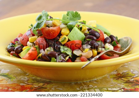Southwestern Black bean salad with avocado, corn, tomato, red onion and cilantro in horizontal format