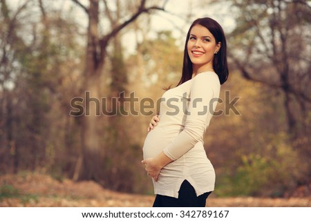 Pregnant woman posing in the park
