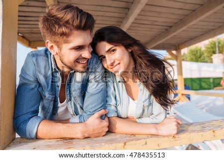 https://thumb1.shutterstock.com/display_pic_with_logo/580987/478435513/stock-photo-young-beautiful-woman-leaning-on-her-boyfriend-shoulder-while-standing-at-the-wooden-beach-house-478435513.jpg