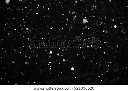 Falling snow on black background.