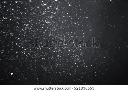 Falling snow on black background.