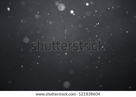 Falling snow on black background.