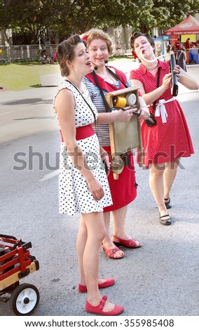 Montreal Quebec Canada - July 20 2014 Acapella washboard trio ladies in old fashioned hair and retro 60's clothing and singing old style music on the street at Festival Just For Laughs