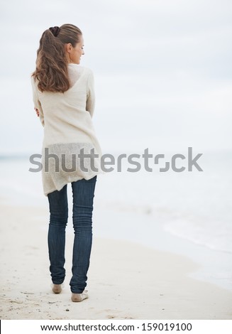 https://thumb1.shutterstock.com/display_pic_with_logo/603946/159019100/stock-photo-young-woman-in-sweater-walking-on-lonely-beach-rear-view-159019100.jpg