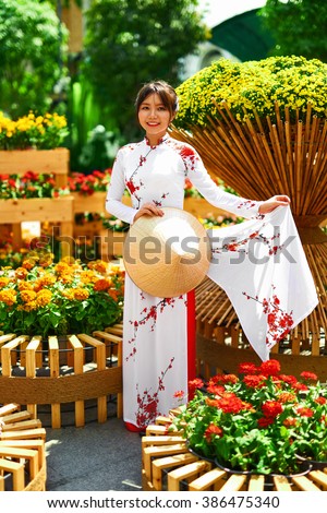 Traditional Clothing Of Vietnam, Asia. Beautiful Happy Asian Girl Dressed In National Traditional Ao Dai Dress ( Costume ), Vietnamese Conical Hat ( Non La, Leaf Hat )