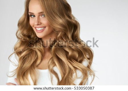Beautiful Curly Hair. Smiling Girl With Healthy Wavy Long Blonde Hair. Portrait Happy Woman With Beauty Face, Sexy Makeup And Perfect Hair Curls. Volume, Hairstyle, Hairdressing Concept. High Quality