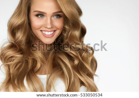 Beautiful Curly Hair. Smiling Girl With Healthy Wavy Long Blonde Hair. Portrait Happy Woman With Beauty Face, Sexy Makeup And Perfect Hair Curls. Volume, Hairstyle, Hairdressing Concept. High Quality