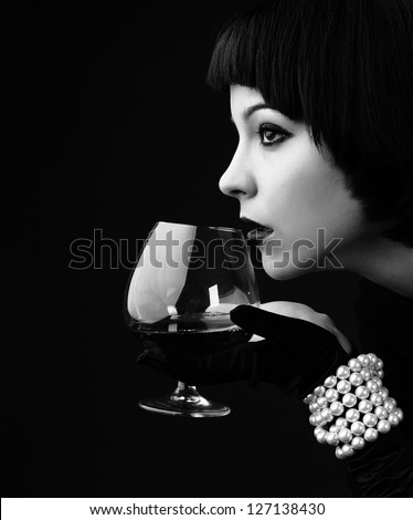 Black and white vintage styled portrait of a young beautiful woman with glass of alcohol Black and white vintage styled portrait of a young beautiful woman with glass of alcohol