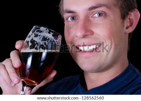 adult male drinking a dark beer isolated on a black background