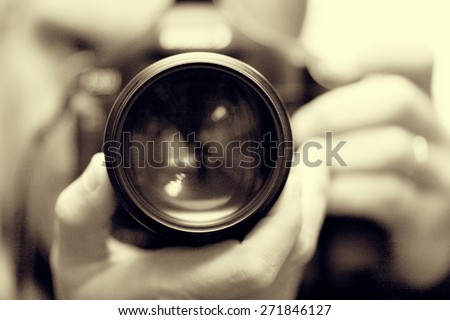 photographer with camera in hand looking through the camera lens