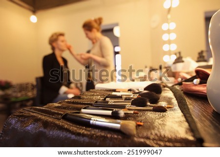 Stylist applying make up for bride on the wedding day with focus on the brushes