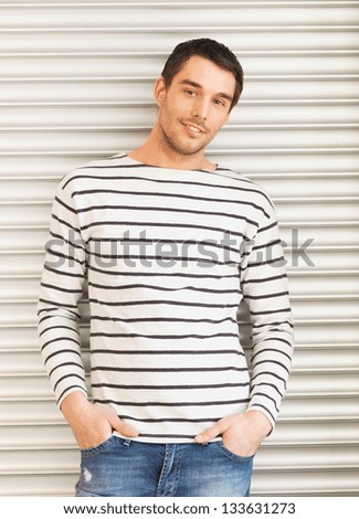 portrait of handsome man in casual clothes leaning to wall