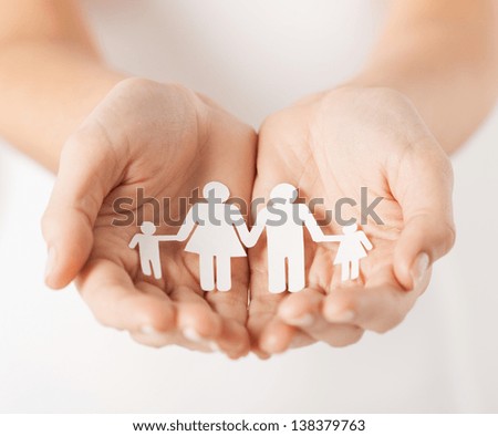 close up of womans cupped hands showing paper man family