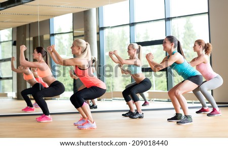 fitness, sport, training, gym and lifestyle concept - group of women working out in gym