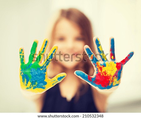 education, school, art and painitng concept - little student girl showing painted hands