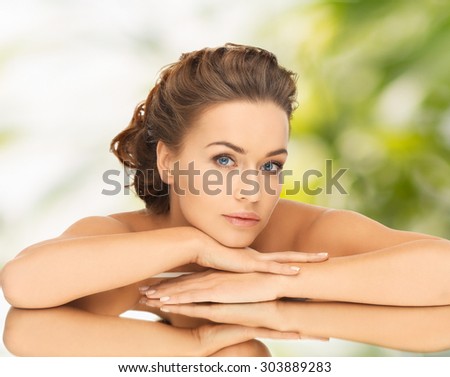 health and beauty concept - dreaming woman with updo and mirror