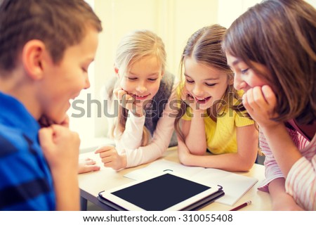 education, elementary school, learning, technology and people concept - group of school kids with tablet pc computer having fun on break in classroom
