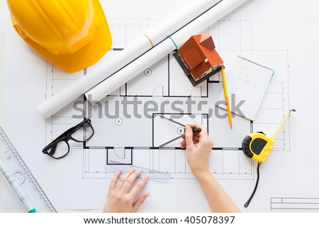 business, architecture, building, construction and people concept - close up of architect hands with compass measuring living house blueprint