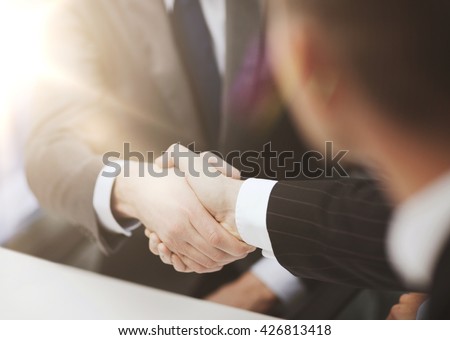 businesss and office concept - two businessmen shaking hands in office