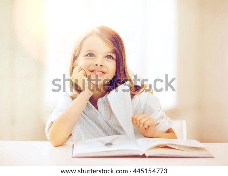 education and school concept - little student girl studying at school