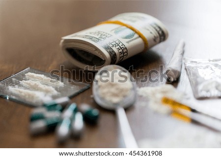 drug use, crime, addiction and substance abuse concept - close up of drugs with money, spoon and syringe