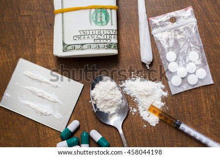 drug use, crime, addiction and substance abuse concept - close up of drugs with money, spoon and syringe