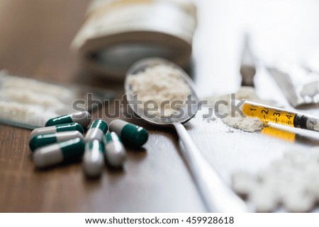 drug use, crime, addiction and substance abuse concept - close up of drugs with money, spoon and syringe
