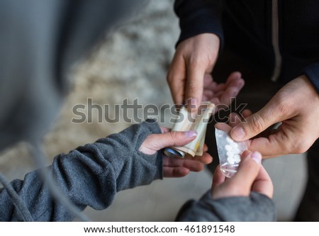 drug trafficking, crime, addiction and sale concept - close up of addict with money buying dose from dealer on street