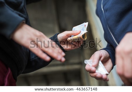 drug trafficking, crime, addiction and sale concept - close up of addict with money buying dose from dealer on street