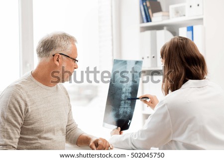 medicine, healthcare, surgery, radiology and people concept - doctor showing x-ray of spine to senior man at hospital