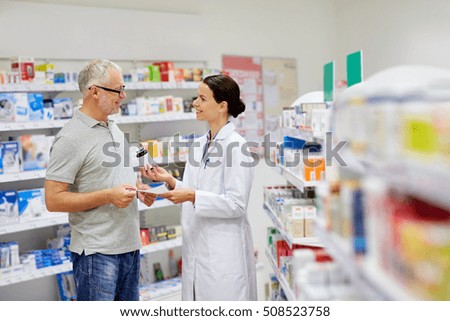 medicine, pharmaceutics, health care and people concept - happy pharmacist giving drug to senior man customer and taking prescription at drugstore
