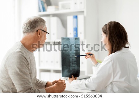 medicine, healthcare, surgery, radiology and people concept - doctor showing x-ray of spine to senior man at hospital