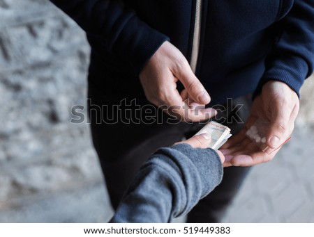 drug trafficking, crime, addiction and sale concept - close up of addict with money buying dose from dealer on street