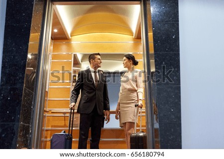 https://thumb1.shutterstock.com/display_pic_with_logo/64260/656180794/stock-photo-business-trip-and-people-concept-man-and-woman-with-travel-bags-in-hotel-elevator-656180794.jpg