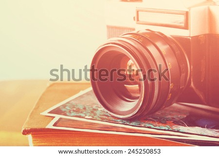 close up photo of old camera lens over wooden table. image is retro filtered. selective focus