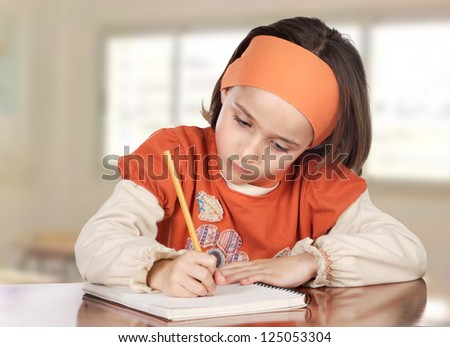 Adorable girl studying in the school with a window of background