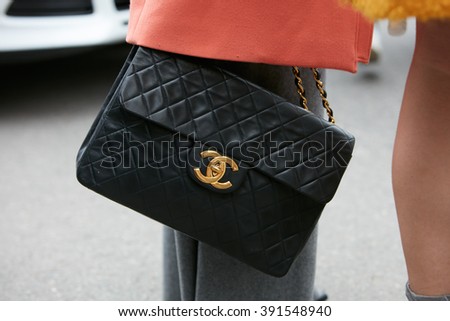 MILAN - FEBRUARY 26: Woman poses for photographers with Chanel bag with golden logo before Etro and Iceberg fashion show, Milan Fashion Week Day 3 street style on February 26, 2016 in Milan.