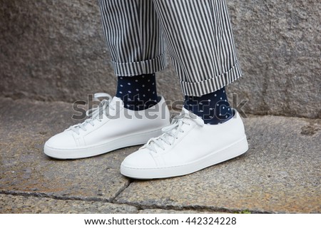 MILAN - FEBRUARY 19: Man poses for photographers with white sneakers shoes before Missoni fashion show, Milan Men's Fashion Week street style on June 19, 2016 in Milan.