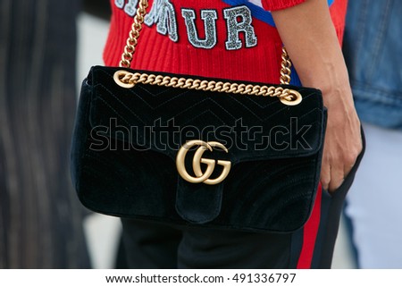 MILAN - SEPTEMBER 21: Woman with black velvet Gucci bag before Gucci fashion show, Milan Fashion Week street style on September 21, 2016 in Milan.